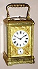 French, carriage clock, half hour strike with quarter hour repeat at will and with alarm, 8 day spring driven movement with platform lever escapement in a Gorge case, with profuse Rococo patterns cast and embossed into the mask and exterior surfaces. with Roman numeral porcelain dial surrounded by fancy gilt mask, c1900
