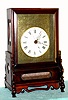 Chinese, double chain fusee, crown verge table clock with stand, a round porcelain dial on a tooled brass mask with oriental designs, and with center seconds hand, 8-day, C.1995 [modern]