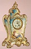 Ansonia Clock Co., NY, Royal Bonn, rare "LA PROVENCE", porcelain cased mantel clock with open escapement and signed portrait below the dial, the largest and most beautiful clock made by Ansonia. 8-day, gong strike. Fancy dial with red tre-foils between the numerals, c.1908
