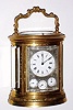 French, Oval and Engraved, brass cased carriage clock, Grande Sonneria [for the Spanish market], with day, date and alarm dials behind a silvered / engraved mask, and with a selector in the base for Grande Sonneria, Silencio, and Cuartos, the days of the week indicated in Spanish abbreviations.
