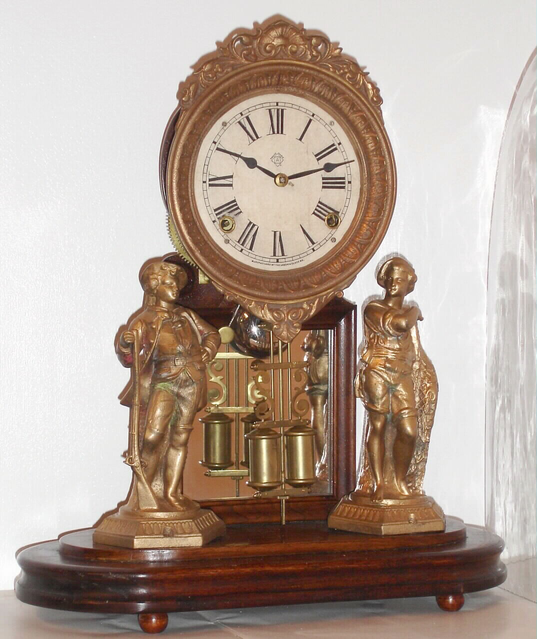 Ansonia Clock Co, "Crystal Palace", showing a hunter and net fisher, and with heavy cast bezel and barrel pendulum, the whole covered by a replacement glass dome, c1880 — Antique Clocks Price Guide