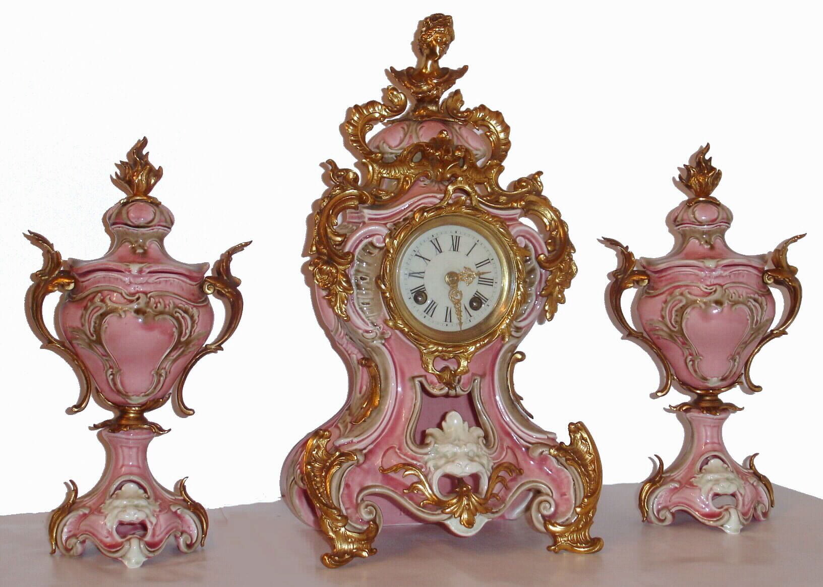 German, Lenzkirch, 3-pc mantel clock set of pink porcelain, the case and side-pieces with gilt metal accents and gold highlights, and the clock with porcelain dial and gilt brass hands, c1885 — Antique Clocks Price Guide