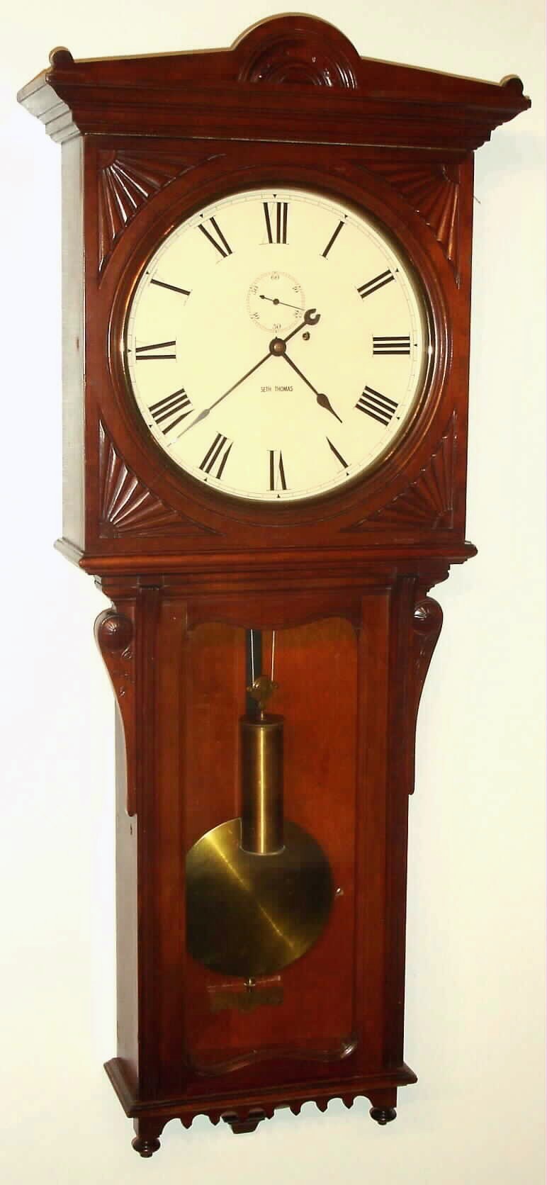 Seth Thomas Clock Co., Thomaston, Conn, "Regulator No. 8" in cherry, 8-day, weight movement, with 12" painted dial, and heavy trapezoidal movement with maintaining power and cut pinions. C.1896 — Antique Clocks Price Guide