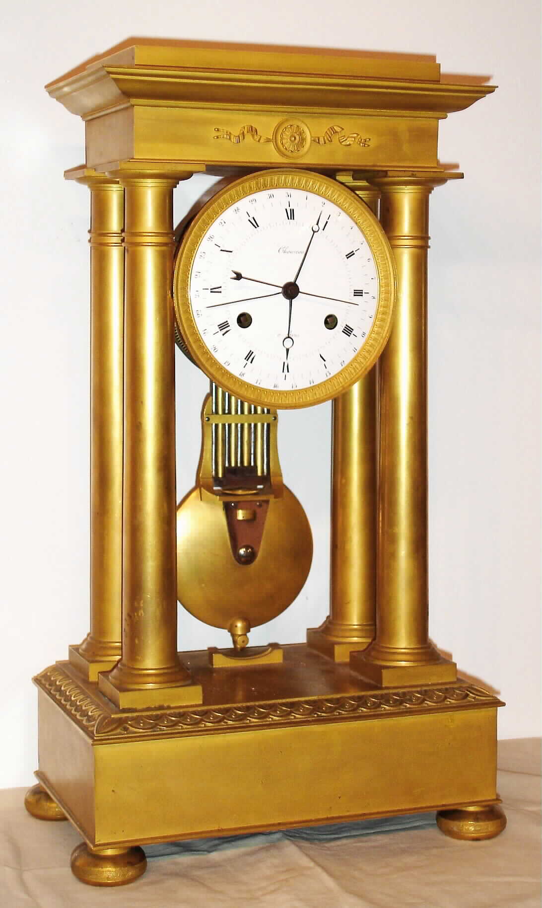 French, Chaveau, Paris, 4-Column Empire mantel clock, bright ormolu case, the well made pinwheel movement with 60 pins in 'scape wheel and affording half seconds on the dial, also with central calendar and knife edge suspension, C.1830. — Antique Clocks Price Guide