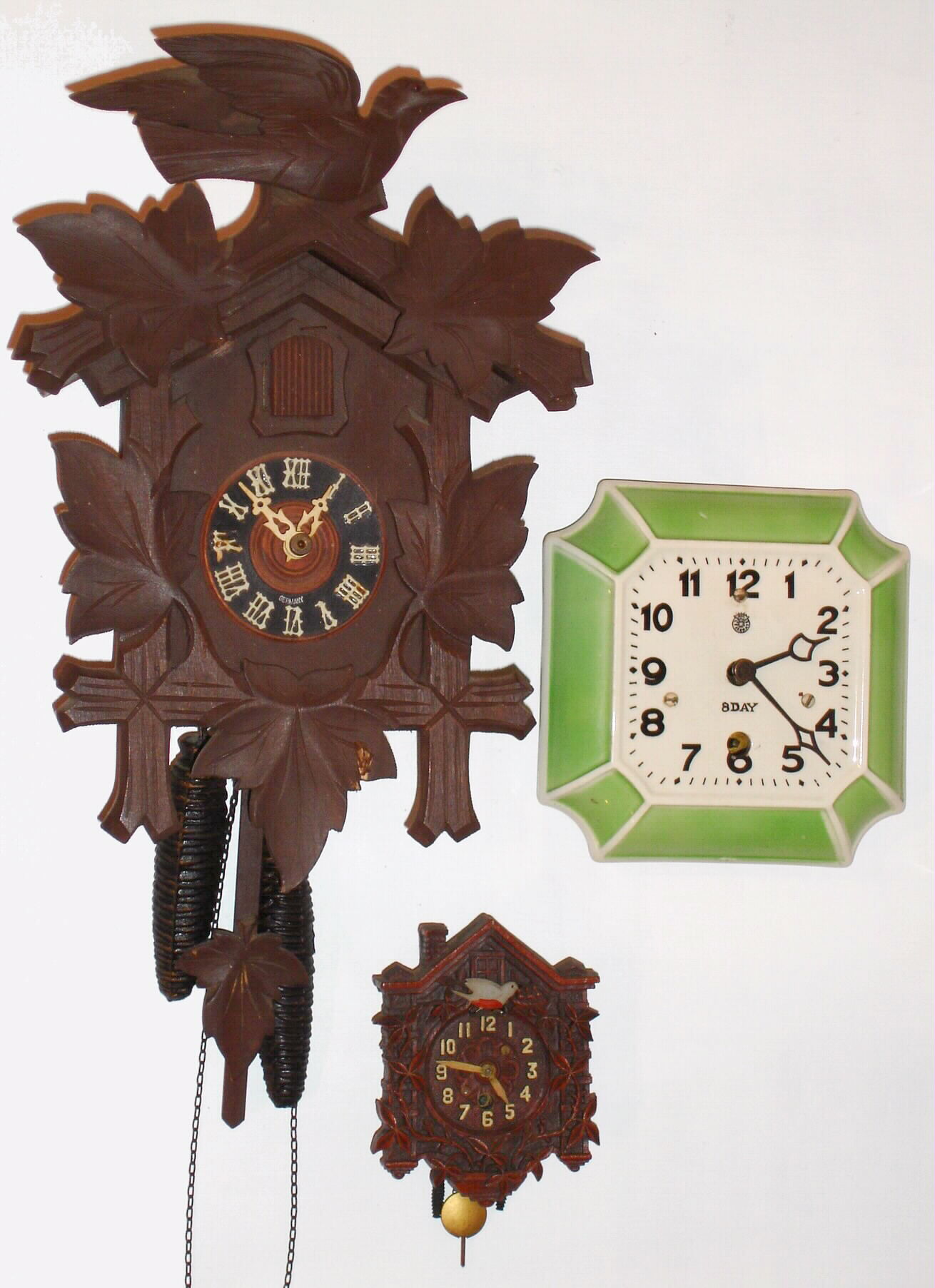 Clocks- (3) wall clocks: a cuckoo with bone hands, a Lux Clock Mfg Co. miniature cuckoo and a Celebrate 8 day porcelain spring driven clock — Antique Clocks Price Guide