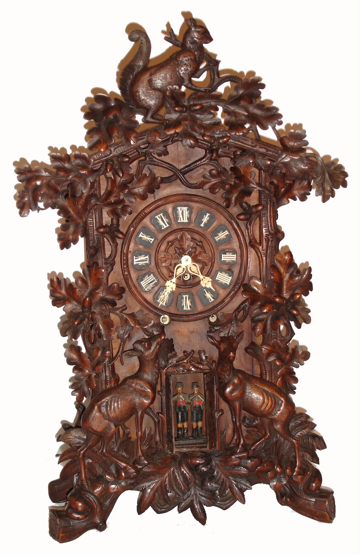 Emilan Wehrle and Co, Trumpeter Clock Factory, Furtwangen, Germany, shelf flute clock, 8 day time, strike and 9-tube flute playing spring driven movement with choice of two tunes. The profusely carved case decorated with deer, squirrels, leaves and acorns also has two carved and painted flautists appearing through doors, bottom of case front. The dial has outstanding and intricately carved bone hands and numerals, c1880 — Antique Clocks Price Guide