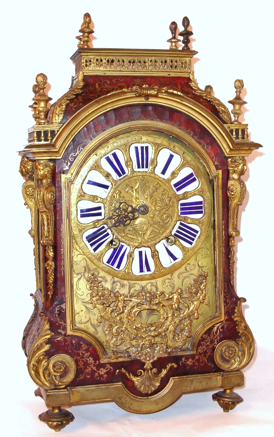 Barthe Dijon, French Louis XIV Boulle type mantel clock with 8 day time and bell strike movement with crown wheel escapement. The tortoise shell veneer case is flanked by four caryatids and is profusely inlaid with brass and some silver highlights. The engraved and embossed brass dial has large enamel cartouche numerals, c1700 — Antique Clocks Price Guide