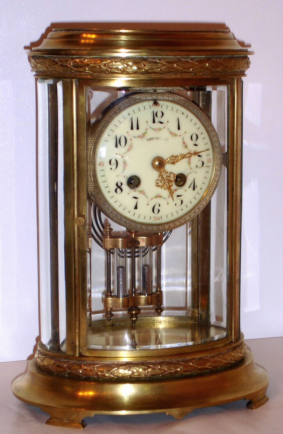French, Marti, 8-day time and gong strike brass and glass crystal regulator retailed by Tiffany and Co, an oval case with acanthus bands surrounding the top and base, and with 2-vial compensating pendulum, C. 1900 — Antique Clocks Price Guide