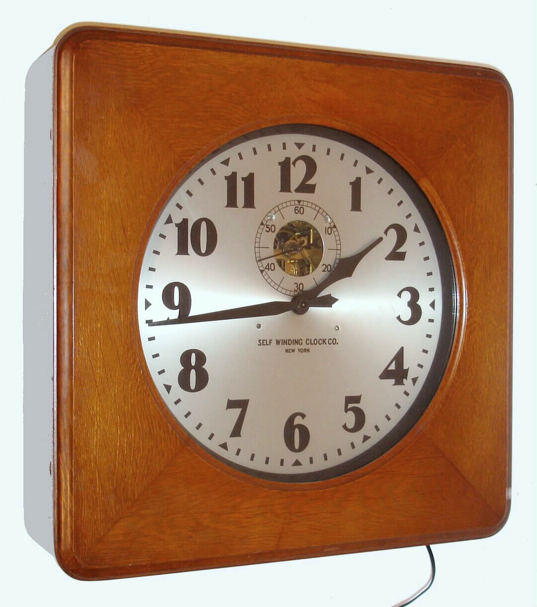 Self Winding Clock Co., New York, time mvt style 29 case, serial No. 183381 in an oak case with a 14" dial, Original paper instructional labels and metallic identification tags present. Converted from battery to wall current and designed for use under lease from Western Union. — Antique Clocks Price Guide