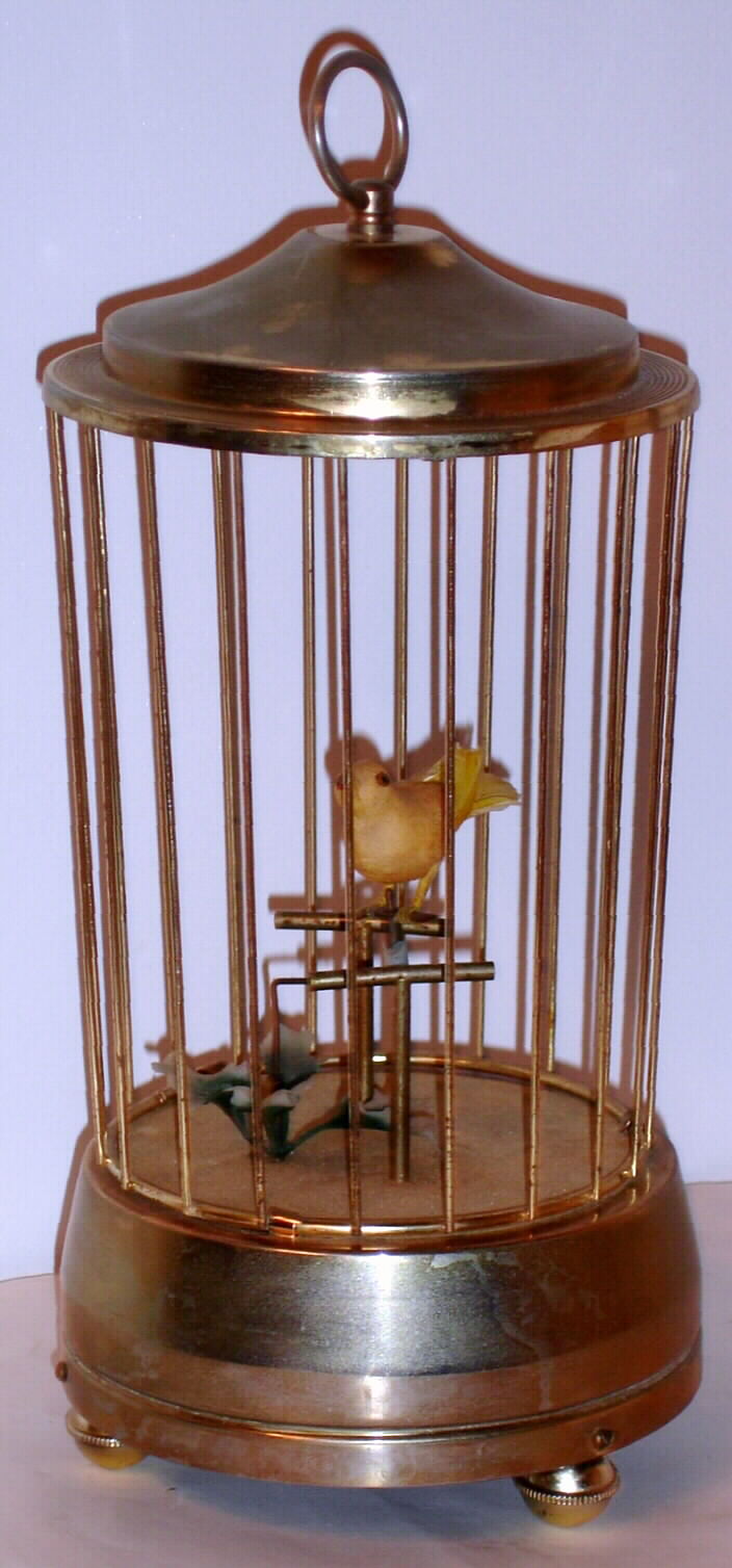 Music box playing "Jingle Bells" with bird in brass cage and mechanical movement, the bird pivots from perch to perch as tune plays, c1960 — Antique Clocks Price Guide