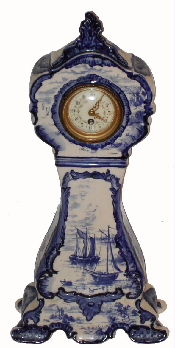 English, in the Dutch blue delft style, porcelain case fitted with a French 8-day balance wheel movement (cylinder escapement). Case is stamped on the back with an English logo. — Antique Clocks Price Guide