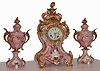 German, Lenzkirch, 3-pc mantel clock set of pink porcelain, the case and side-pieces with gilt metal accents and gold highlights, and the clock with porcelain dial and gilt brass hands, c1885