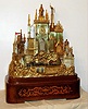 French, Napoleon III, ormolu musical and automaton novelty mantel clock, in the form of a castle, time and bell strike with silk thread suspension, c.1870, less dome, two "trains" with early style locomotives and cars traveling across the front on two bands, driven by an independent spring barrel, the plinth also housing a musical movement