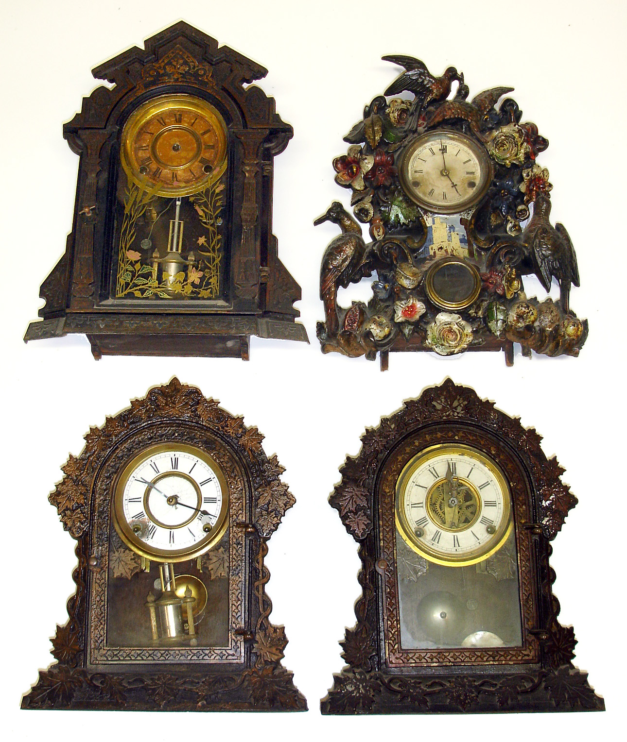 Four 8-day Connecticut cast metal front mantel clocks. Two of the same model with leaves, one with drum pendulum and nice glass, largest with birds and multicolor flowers is 17" high. — Antique Clocks Price Guide