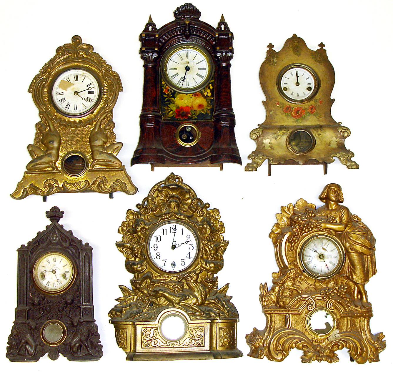 Six 8-day Connecticut iron fronts Large figural gold clock is N. Muller No. 67. One with bold floral and wood grain painting. Also examples by American Clock Co., U.S. Clock Co. dial with Terry and Edwards label, next to last in photo- Terhune and Edwards, NY, and a Waterbury -- the largest at 19" tall. — Antique Clocks Price Guide