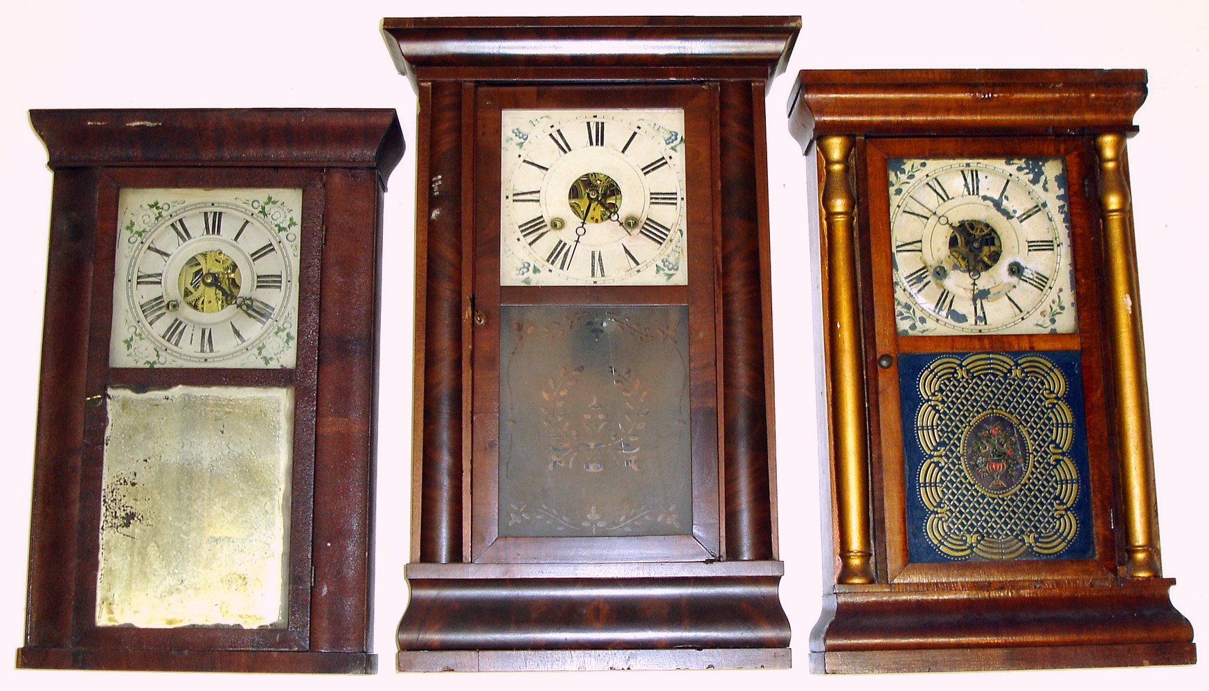 Three Connecticut 30 hour weight driven cornice top shelf clocks. All with inside paper labels. Smallest is Atkins, Porter and Co. cornice top with old mirror tablet. Middle is Seth Thomas, Plymouth Hollow, with lovely gold, blue and floral tablet. Largest, Daniel Pratt, Jr., Reading, Mass., with nearly-flat columns and frosted tablet, is 27" high. — Antique Clocks Price Guide