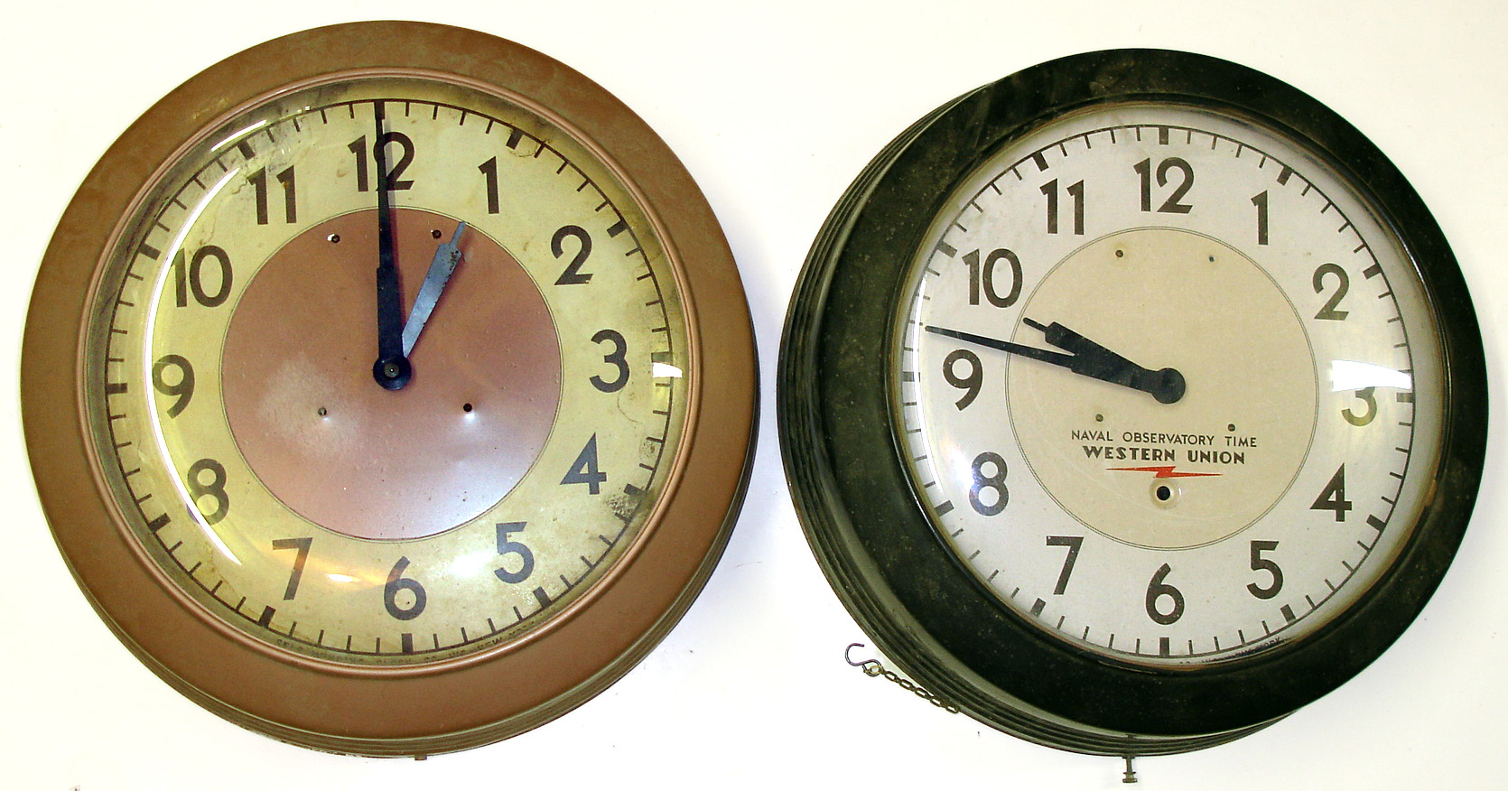Two large Self Winding Clock Co. metal case gallery clocks. Pendulum movements wound electrically with twin dry cells every hour. One with Western Union dial, leased by this company for the distribution of standard time. 14" dials. — Antique Clocks Price Guide