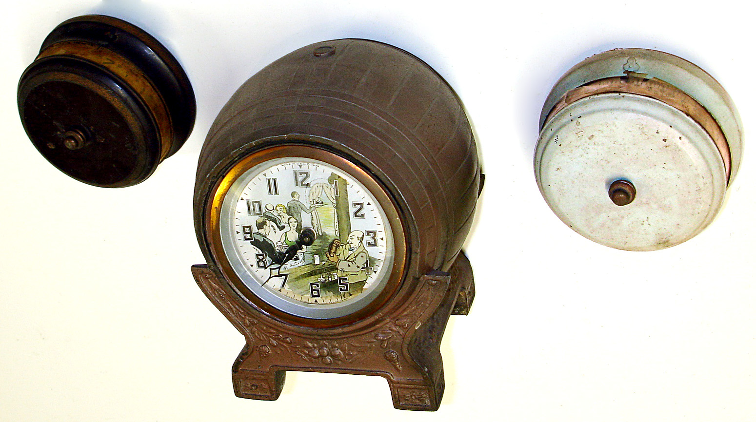 Three American 30 hour metal novelty clocks. Two are Lux "tape measure" horizontal dial. Largest and best is United Clock Co. beer keg with animated dial of bartender shaking cocktails, 9" tall. — Antique Clocks Price Guide