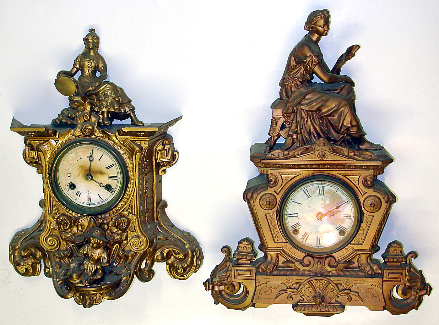 Two Connecticut cast metal 8 day figural mantel clocks, c. 1870. Detailed castings in old finish, shorter clock's top statue not attached and may belong to a different model. Both have replaced paper dials. Standard open spring striking movements will need service. Tallest clock is 21" high. — Antique Clocks Price Guide