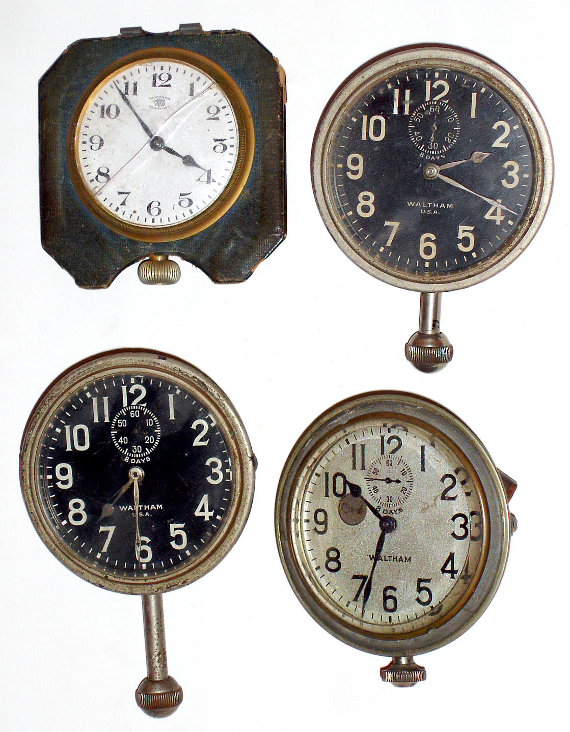 Four Waltham car/travel 8 day clocks: two black dials with seconds tracks, one silver dial with dot wind indicator, one from leather travel case with "Cross" dial. — Antique Clocks Price Guide