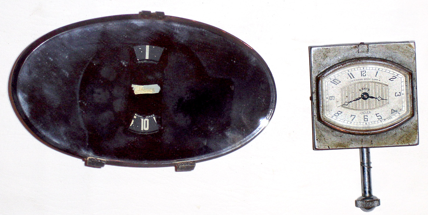 Two Jaeger car clocks: one built into beveled oval rear view mirror with digital numbers showing through; other is 8 day with dial marked "Fleetwood Body Corp'n.", 2.5" square. — Antique Clocks Price Guide
