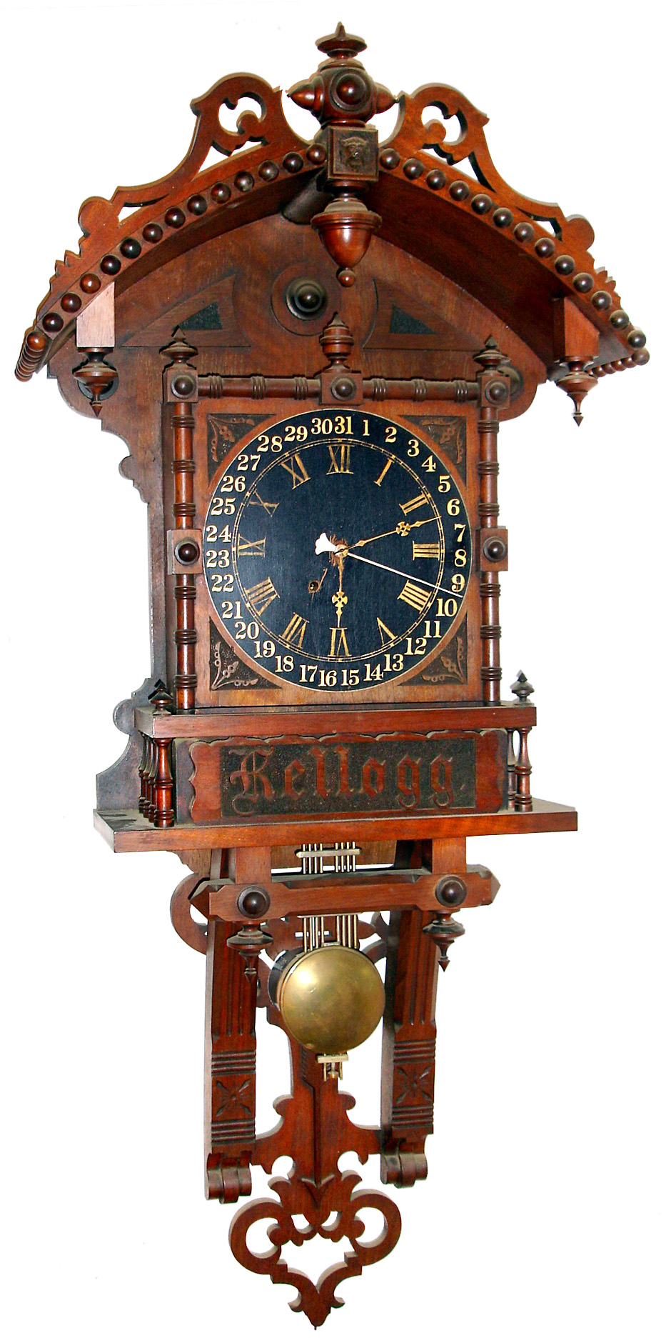 Presentation wall clock for "Kellog", special order probably from New Haven Clock Co., New Haven, Conn., 8 day time and calendar unsigned spring driven movement in ornate walnut case with turnings, finials, cutouts and carvings and black dial with gold numerals painted directly on the case, c1880 — Antique Clocks Price Guide