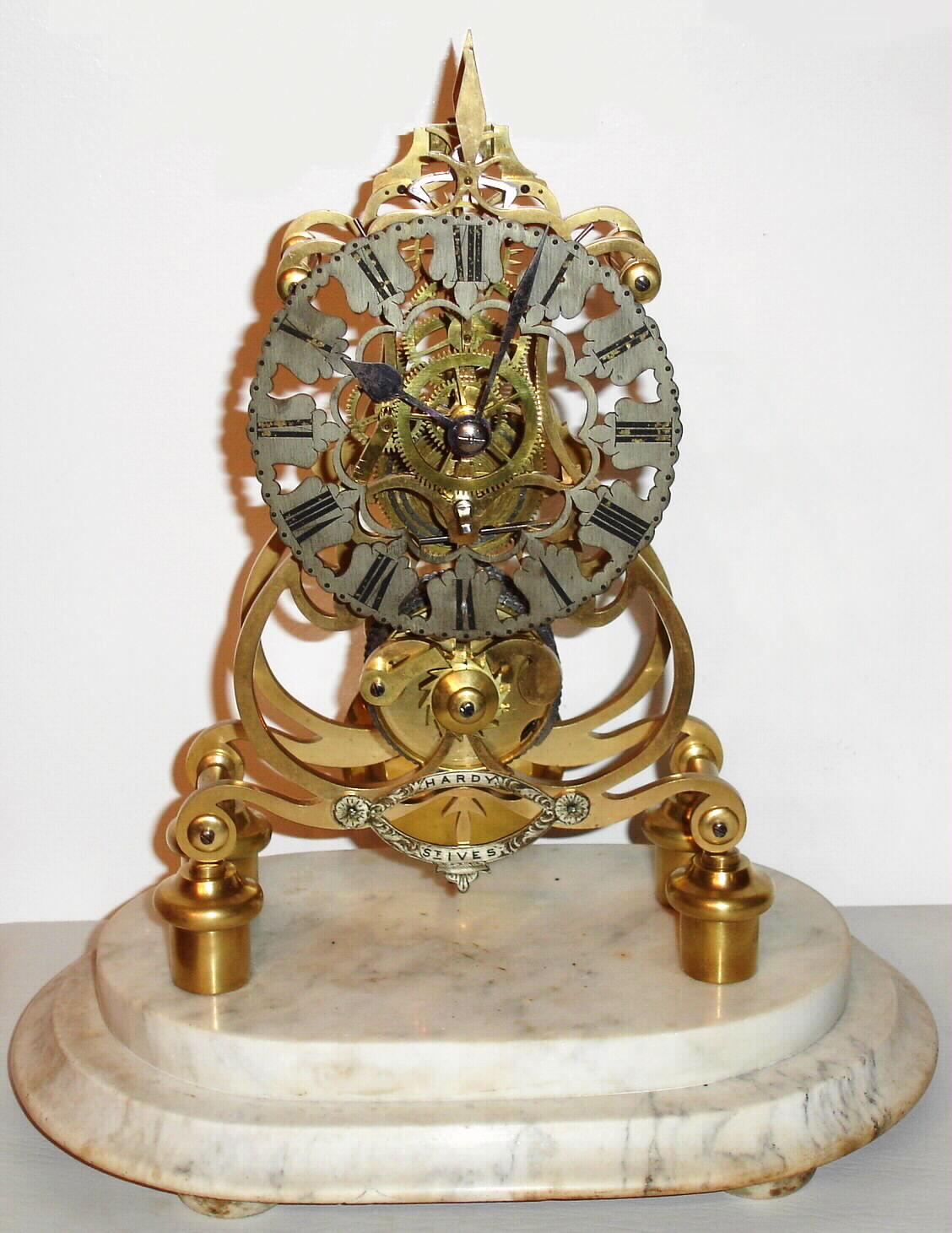 English, Skeleton Clock, by John Smith and Sons, Clerkenwell, bearing the signed silvered plaque of the retailer, "Hardy - St. Ives", less dome, with original marble base, scroll frame design on 4 turned feet, c1865 — Antique Clocks Price Guide