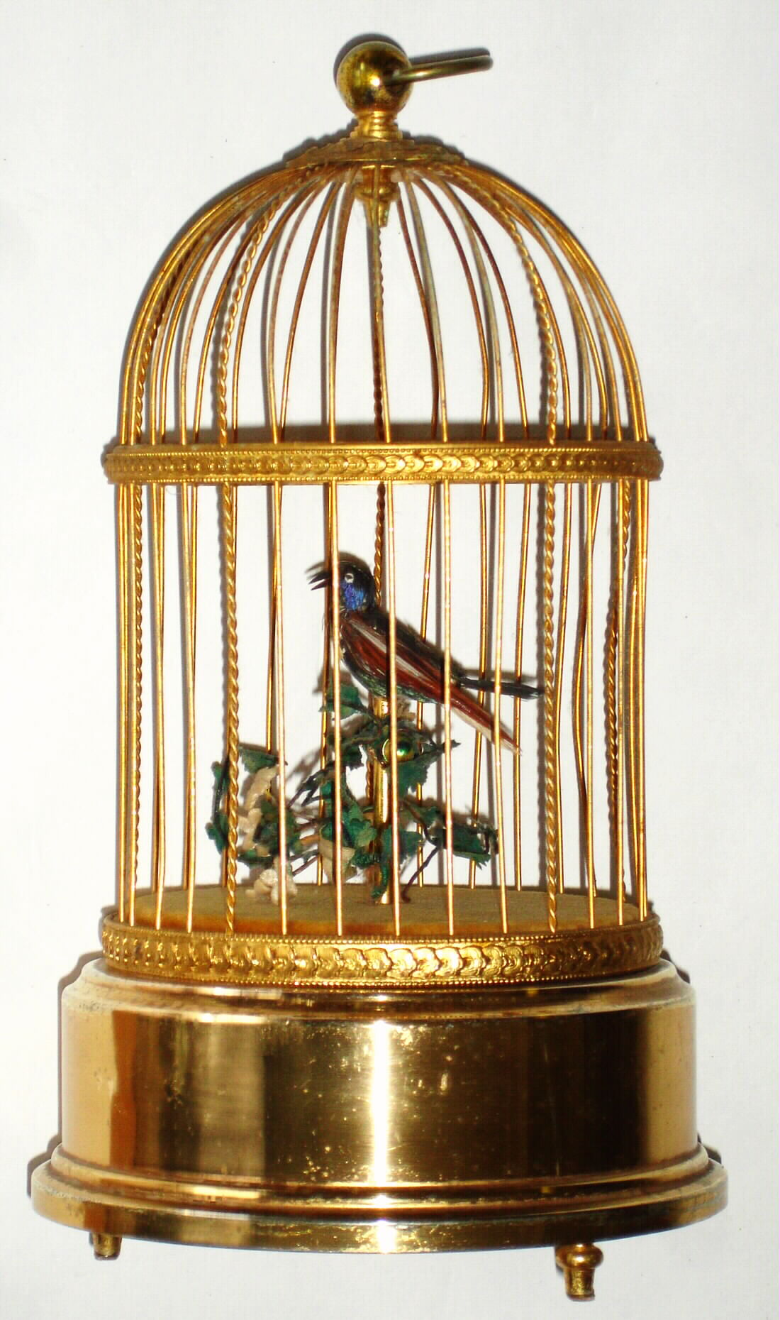 Swiss, Reuge, singing bird in cage, a red-breasted robin with blue cheek feathers setting on a perch in a gold toned brass cage, c1930 — Antique Clocks Price Guide
