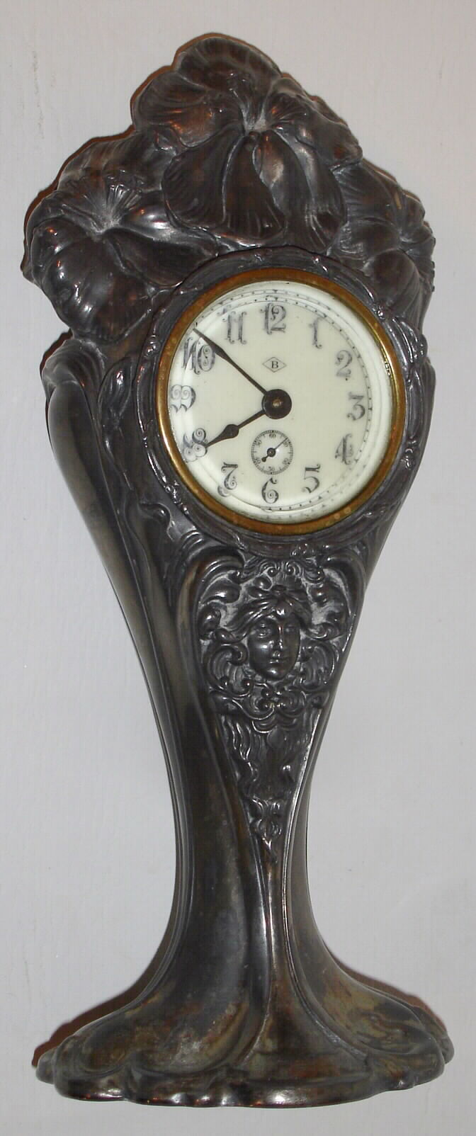 Waterbury Clock Co., 30 hour cast metal case novelty timepiece. Plated silver case made by the Benedict Mfg. Co. of East Syracuse, NY, who were in business from 1894 to 1953. The movements supplied by Waterbury, c1914. This timepiece was manufactured by Waterbury as part of their business of manufacturing sterling and silver-plate items. — Antique Clocks Price Guide