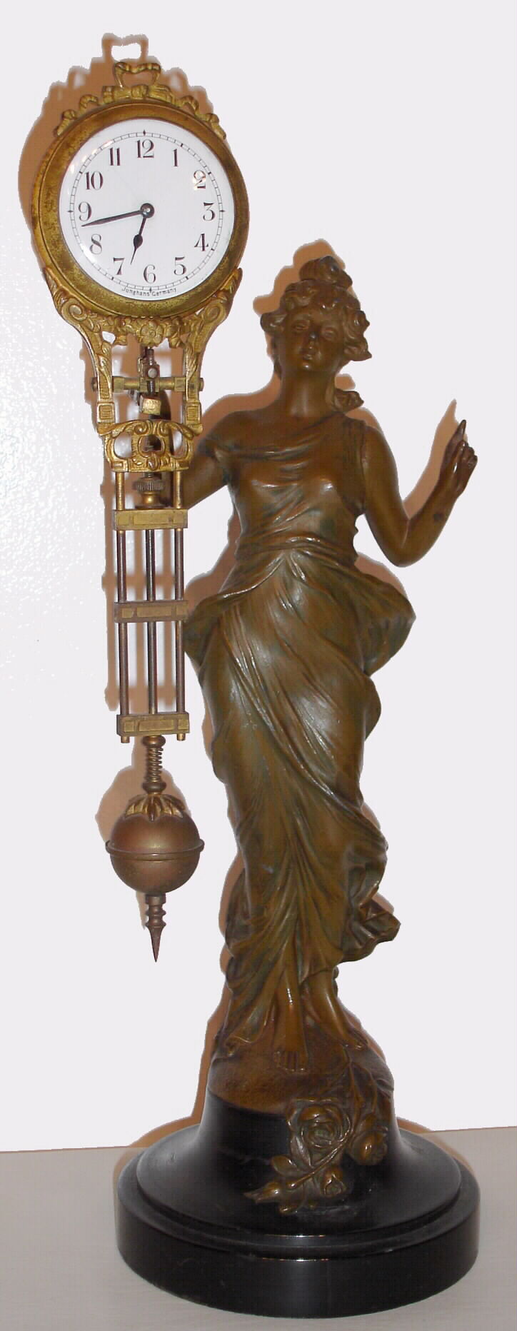 Junghans, Germany, "Diana", swinging arm novelty 8 day timepiece. The patinated spelter statue is affixed to a turned wooden base and a small well made movement is housed in the top of the 'clock arm'. — Antique Clocks Price Guide