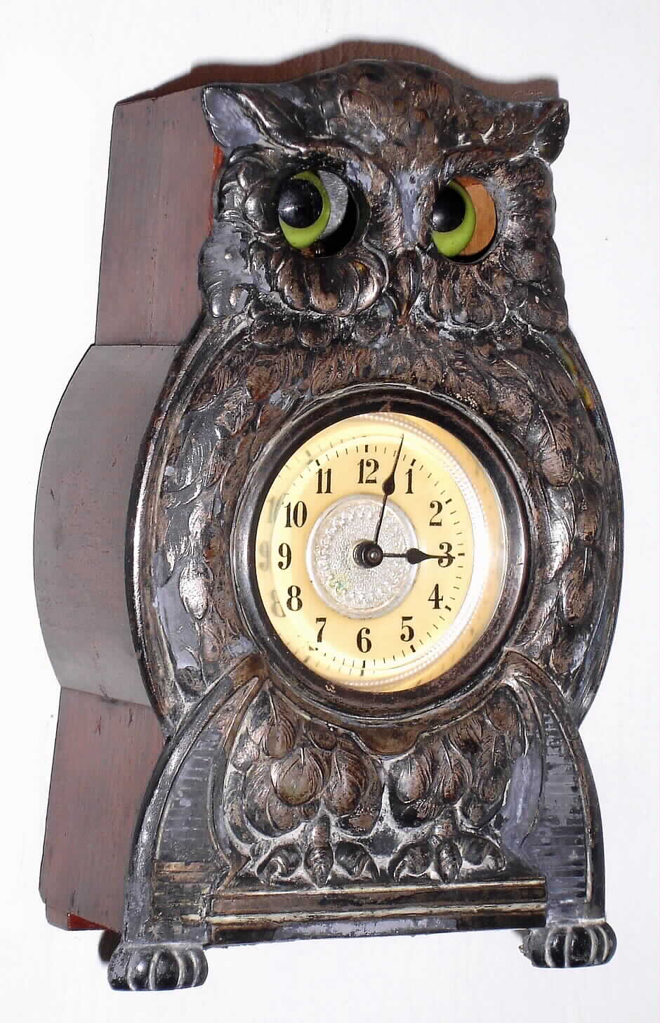 Owl novelty clock German or Swiss with moving eyes and cast white metal front inset with Arabic numeral dial all on wooden housing for movement, c1920 — Antique Clocks Price Guide
