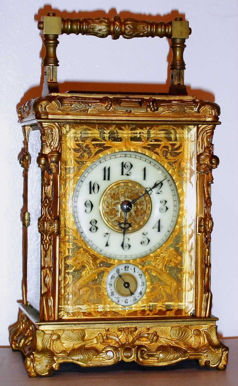 French carriage clock time and half hour strike on gong with alarm and platform lever escapement in embossed Rococo case with pierced gilt mask decorated with lions around Arabic numeral enamel chapter ring, c1900 — Antique Clocks Price Guide