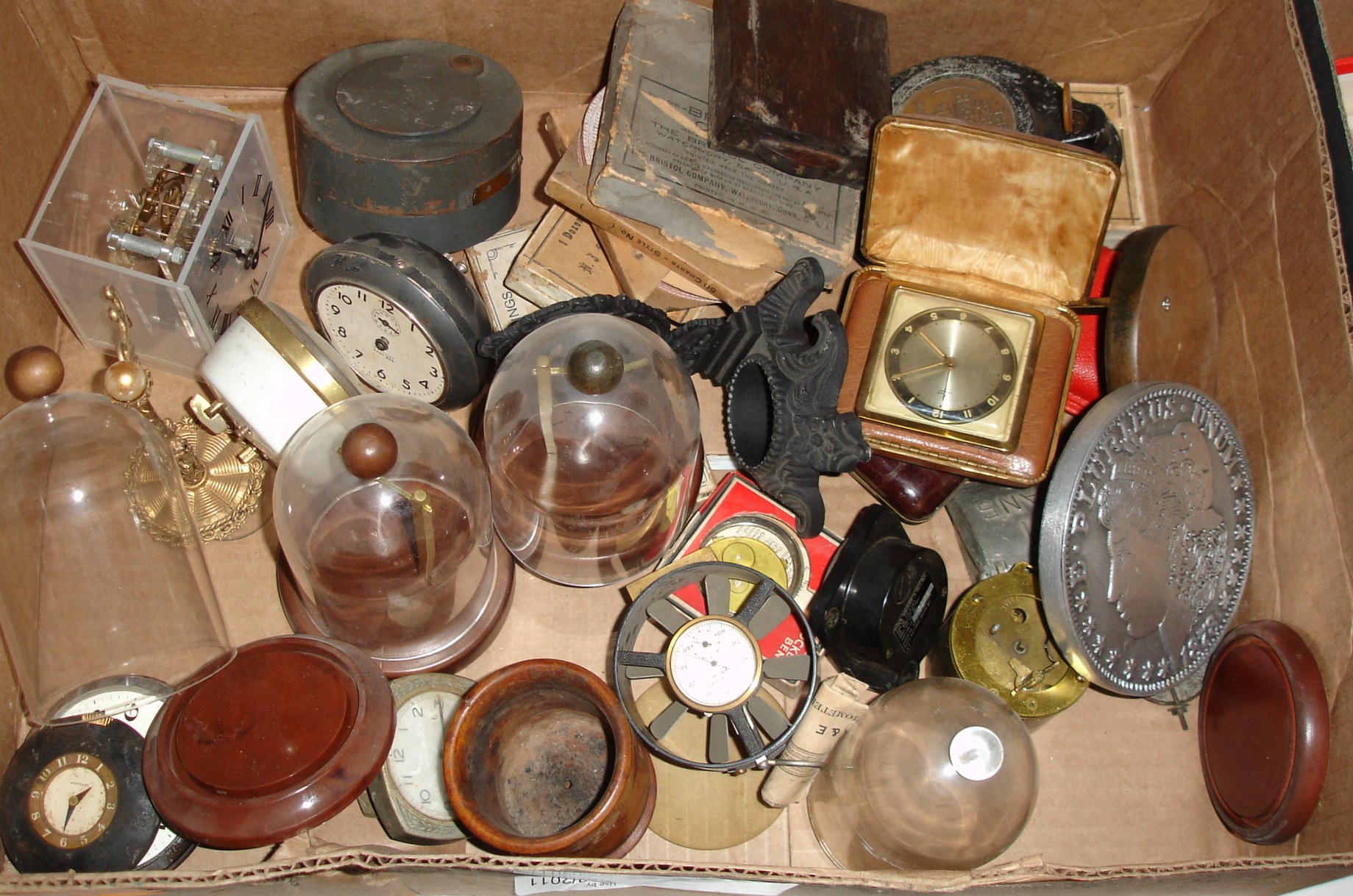 Large box lot of travel clocks, watch display stands, a cast iron watch hutch, figures, movements, movement brackets, navigational watch holder, mainsprings, etc. — Antique Clocks Price Guide