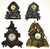 Four cast metal figural mantel clocks. Highly detailed castings, 2 with dogs (1 a Waterbury). Largest, with winged angel and United electric works, is 16" tall.