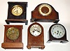 Five wood case 8-day mantel clocks. Two from England (Enfield and Davall), alarm clocks by Seth Thomas and National. Tallest, unsigned, is 11" high