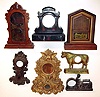 Seven clock cases- one French black marble, two mahogany including a cottage and parlor. There are also four cast metal including one gold iron front and an advertising "Durham Cigar". Tallest is 20".
