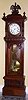 German "Alt Deutsch" style tall case with later Swiss pinwheel escapement movement and high grade grid iron pendulum. The case is mahogany with carvings and turnings and surmounted by carved crowned eagle finial. The porcelain enamel dial has sweep seconds, c1880