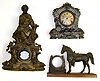Three cast-metal clock cases (no movements). Horse and lucky horseshoe figural has wooden base. Silvery finish is a cast front with wood movement box. Best is very large figural of seated lady, 22" tall.