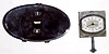 Two Jaeger car clocks: one built into beveled oval rear view mirror with digital numbers showing through; other is 8 day with dial marked "Fleetwood Body Corp'n.", 2.5" square.