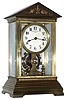 Eureka Clock Co. Ltd., London, England battery powered mantel clock in architectural crystal regulator type case with beveled glass and applied swan and urn decorations in pediment with mechanical movement electrically driven with oversized balance wheel, c1910