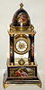 Austrian, unsigned Royal Vienna case, blue cobalt, in the Empire style with 4 columns, the base and top dome with finely detailed cameos showing amorous/pastoral scenes, all brightly trimmed in gold, and with an 8 day cylinder platform movement suspended from the top (wound from the rear), c1870