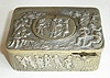 Swiss, Singing Bird Box, an embossed silver case featuring village scenes of people in period costumes, some dancing, some in a musical group, others sitting, holding hands, even the very bottom panel includes a couple dancing on the beach, with a pipe smoking on-looker. A hinged snuff box lid in the rear shows a farmer's wife milking a cow, and sheep in the field, c1925