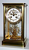 French, 4-glass crystal regulator with uncommon detached balance wheel in the form of a ship's wheel, the wheel rolling a carriage mounted to the base of the case, and a long crutch extending to an impulse pin on the rear of the wheel . The escapement, with large ruby jewels, is visible on the dial, c1900
