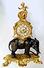 French, L'Elephant, in the style of a century earlier, bronze and ormolu, the clock mounted above the elephant, surmounted by a winged cherub. The pendulum extends from the movement down through a hole in the top of the elephant (original) and saddle , thus invisible from the outside. The dial with royal blue numerals on fired porcelain cartouches. Original name on dial not legible, however Paris can be read. Case components bear 3 letters L.L.A., c1870