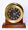 Chelsea Clock Co., Boston, USA, 4.5" black dial naval timepiece, with formerly luminous hands, now painted white, bearing serial number 128960, c1942. Includes a later mahogany desk stand.