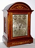 English, large inlaid mahogany quarter chiming bracket clock, 3-fusee, chiming on your choice of 8 bells or 4 gongs [and striking the hours on a deep toned cathedral gong, with a rectangular dial, engraved and silvered, and with subsidiary dials in the arch for Chime / Silent, F /S , and Whittington or Westminster tune, serviced by B. G. Taylor, Marple (Stockport), label on rear of dial. The case with wooden side frets, bun feet, and floral inlay on the canted corner moldings and front panels, + cross banding around the door, sides and top. C.1885.