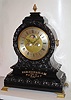 English, J. C. Jennens, London, giant triple fusee bracket clock, quarter chiming, a race award presented to owners of "Benazit", and with large brass letters screwed the base = "Birmingham, Won By Benazit, 1869". With a very large and robust movement, with round silvered dial containing in its center a Halifax rolling moon, days of the week dial to left and a simple calendar dial (1-31) to the right. Playing the Westminster tune on 4 large and deep toned bells, and striking the hours on an extra large cathedral gong. The balloon shaped case with floral carving to the front, c1869