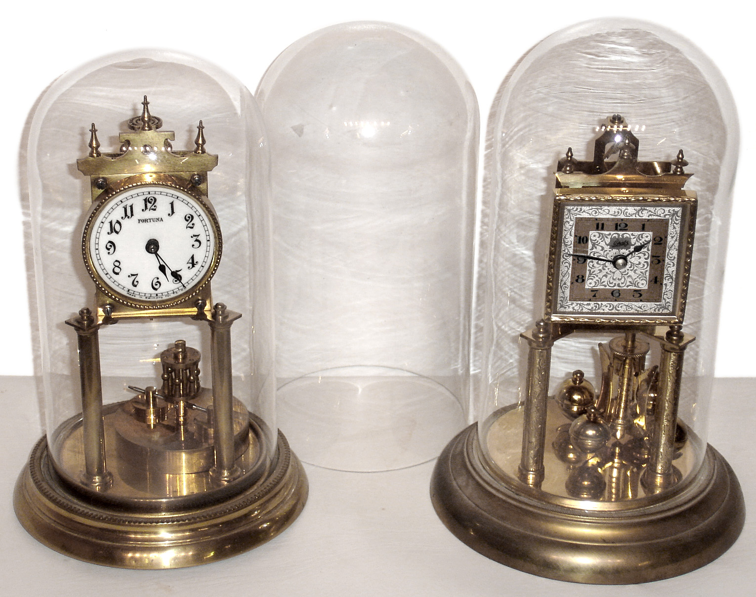 Clocks- 2 (Two) German 400 day anniversary timepieces, 1 with disk pendulum, plus an extra glass dome, 20th century — Antique Clocks Price Guide