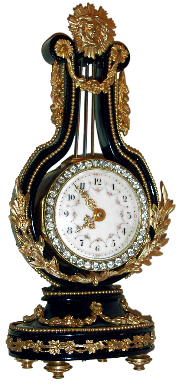 French, miniature lyre form timepiece with gilt elements, applied to an ebonized wood frame, and brilliant surround run by an 8 day platform escapement movement, c1900. — Antique Clocks Price Guide