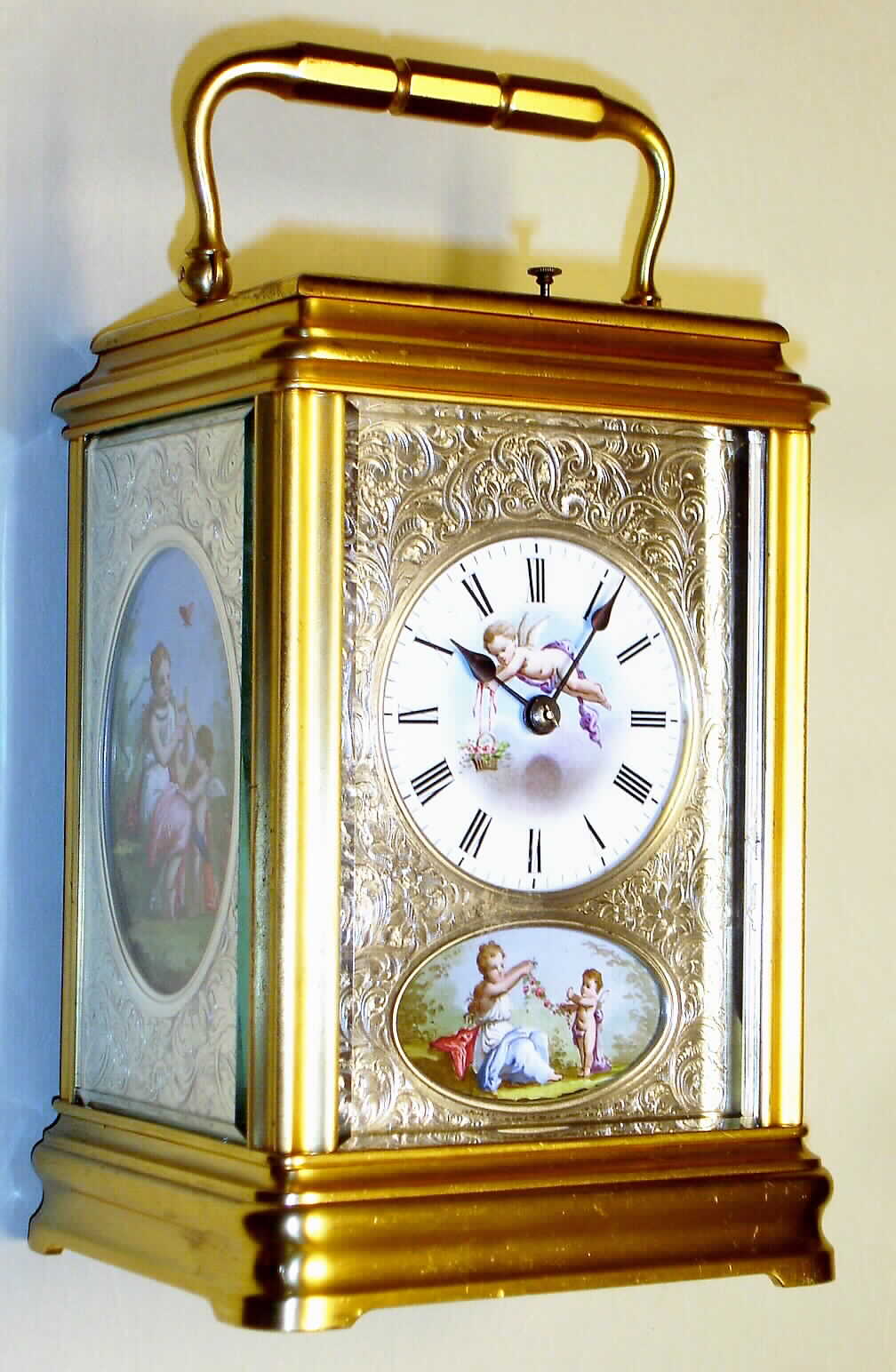 France, carriage clock in gilded brass cannelee case with multicolor painted porcelain panels each having a finely engraved silver mask, 8 day, time, half hour strike and hour repeat with Roman numeral white enamel dial, c1890 — Antique Clocks Price Guide